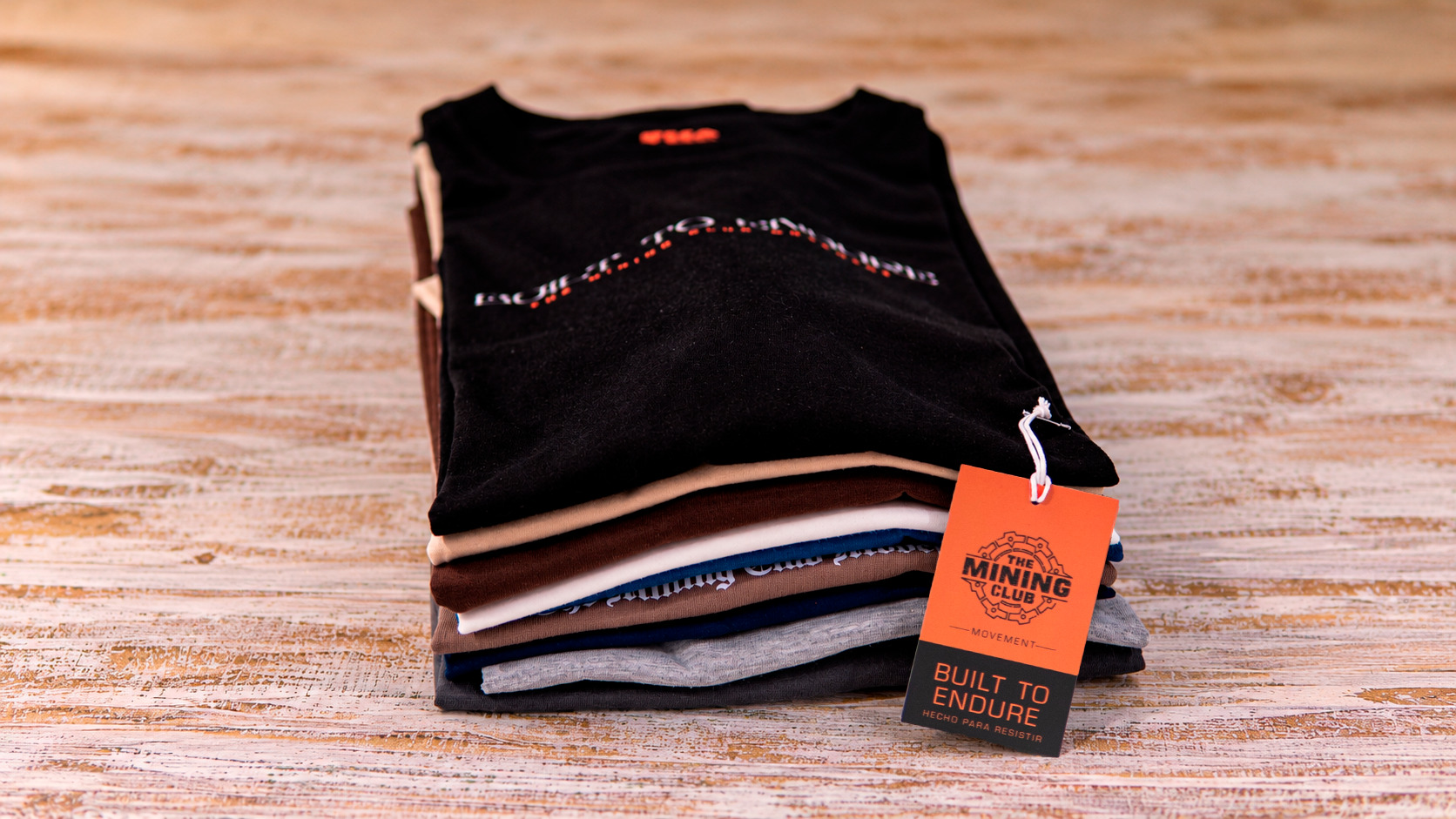 Polos y etiqueta de The Mining Club sobre una mesa de madera